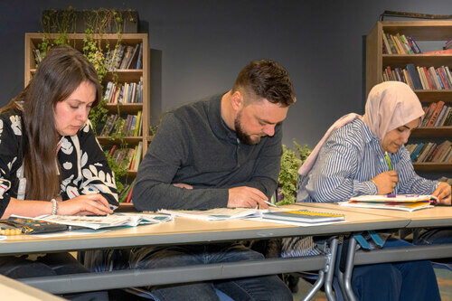 Three individuals working on school work